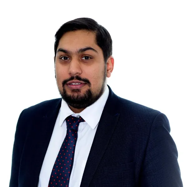Head and body shot of Harish. He is in a suit and tie, with a serious look, arms down to his side, body angled to the left and he is looking directly at the camera.