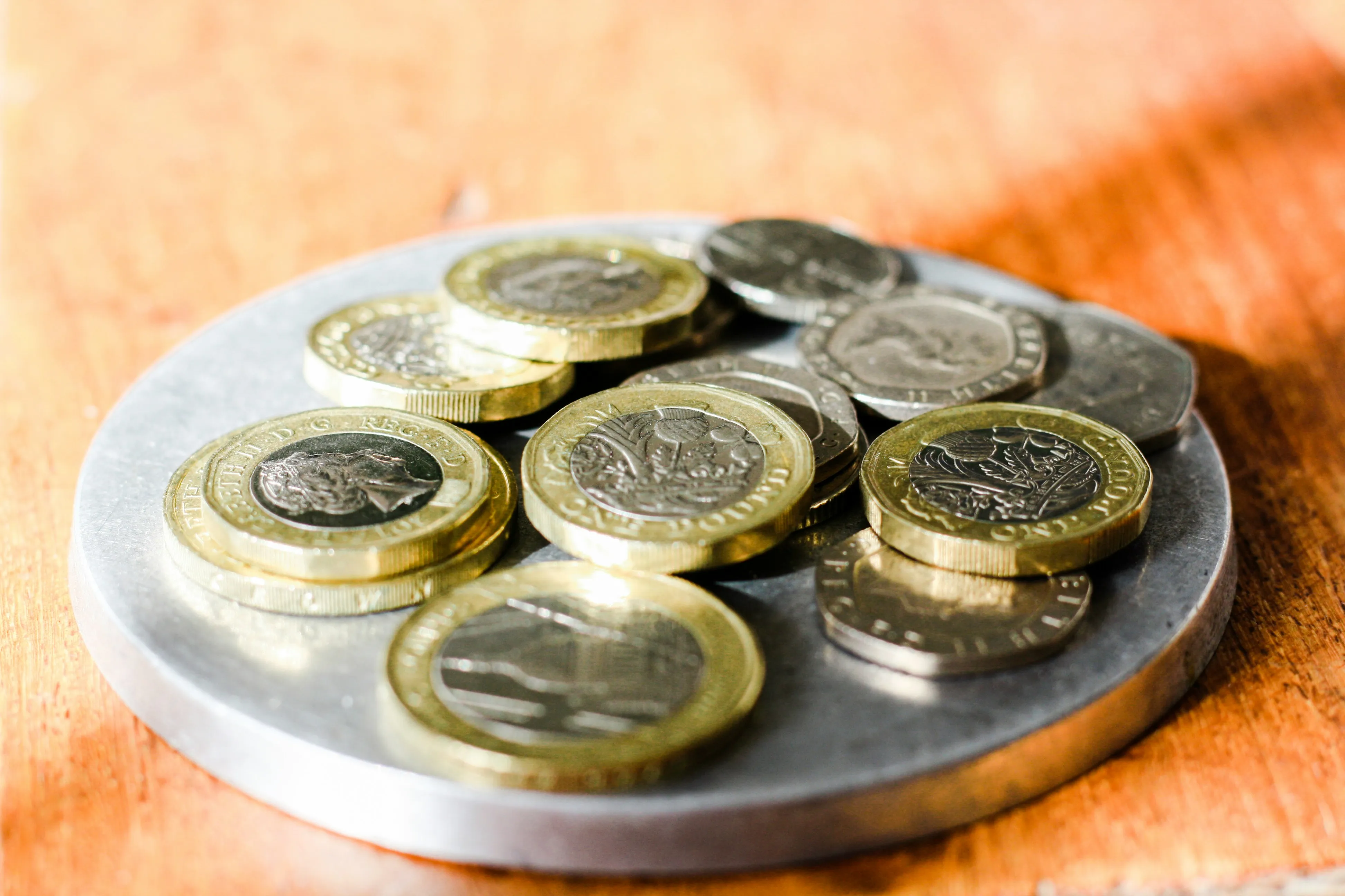 Pile of various coins on a round coaster.