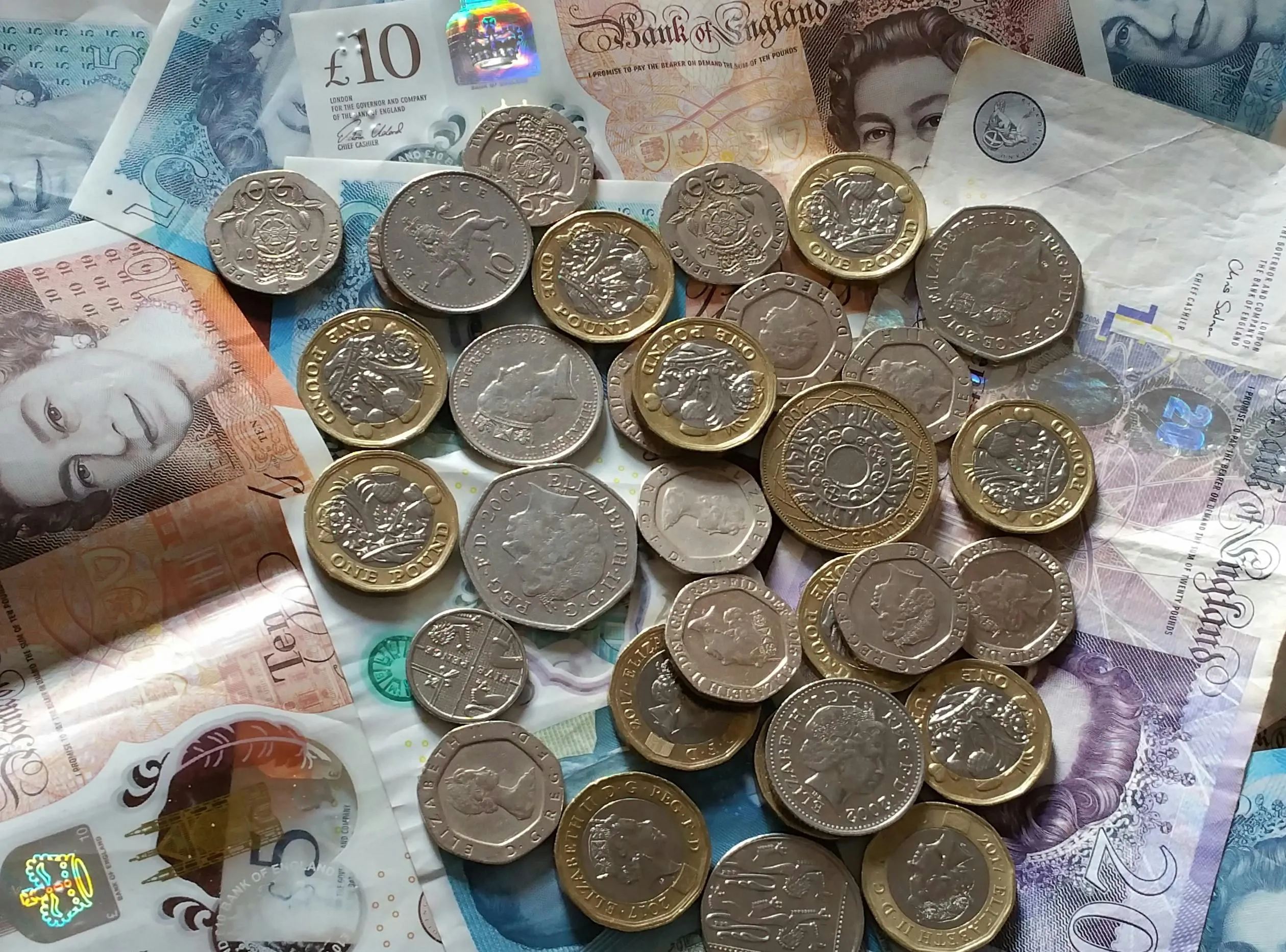 Pile of British Pound notes and coins.